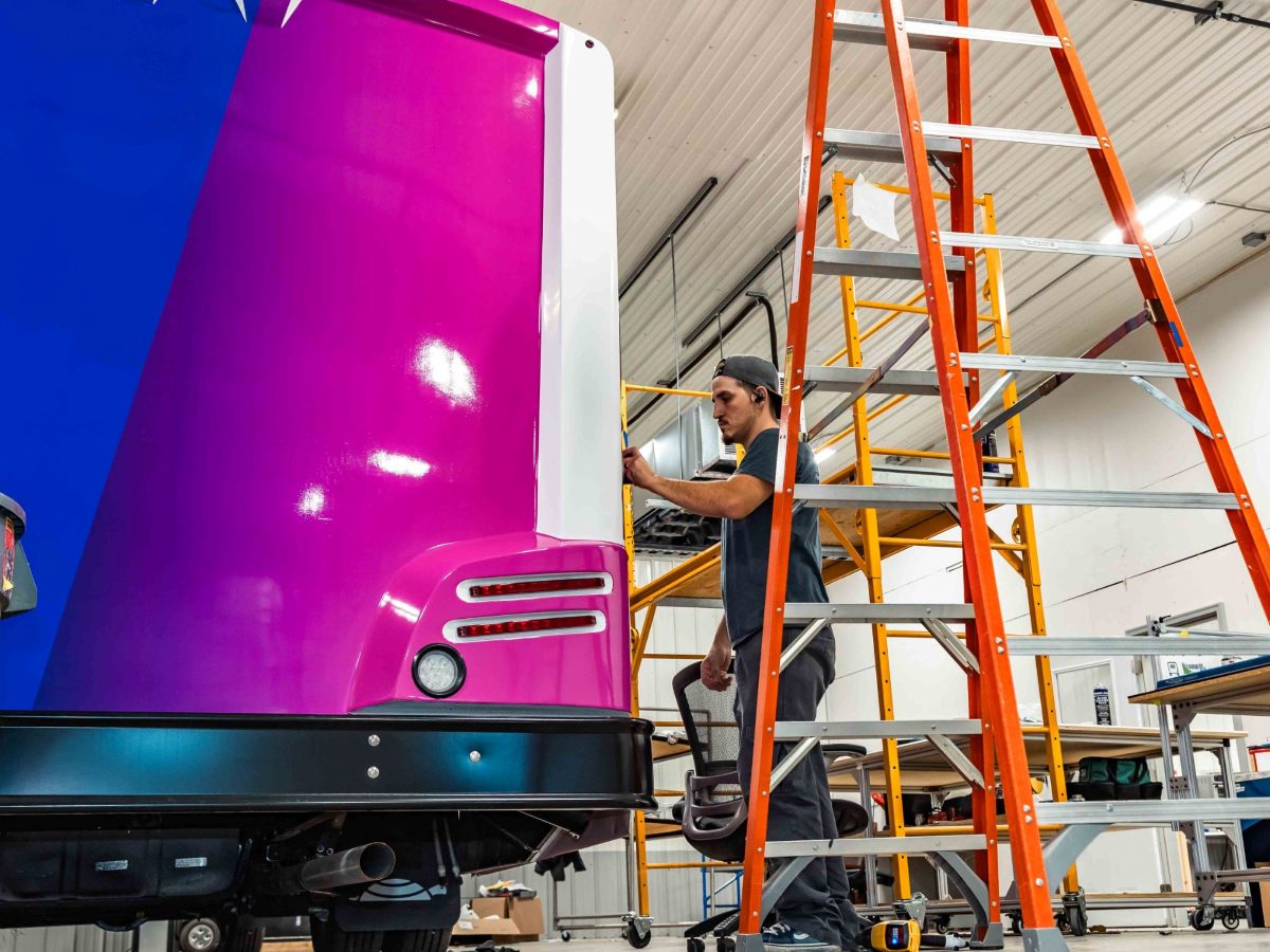 custom-vehicle-graphics A TESCO Specialty Vehicles technician installing a custom wrap on a specialty vehicle in the in-house graphics shop