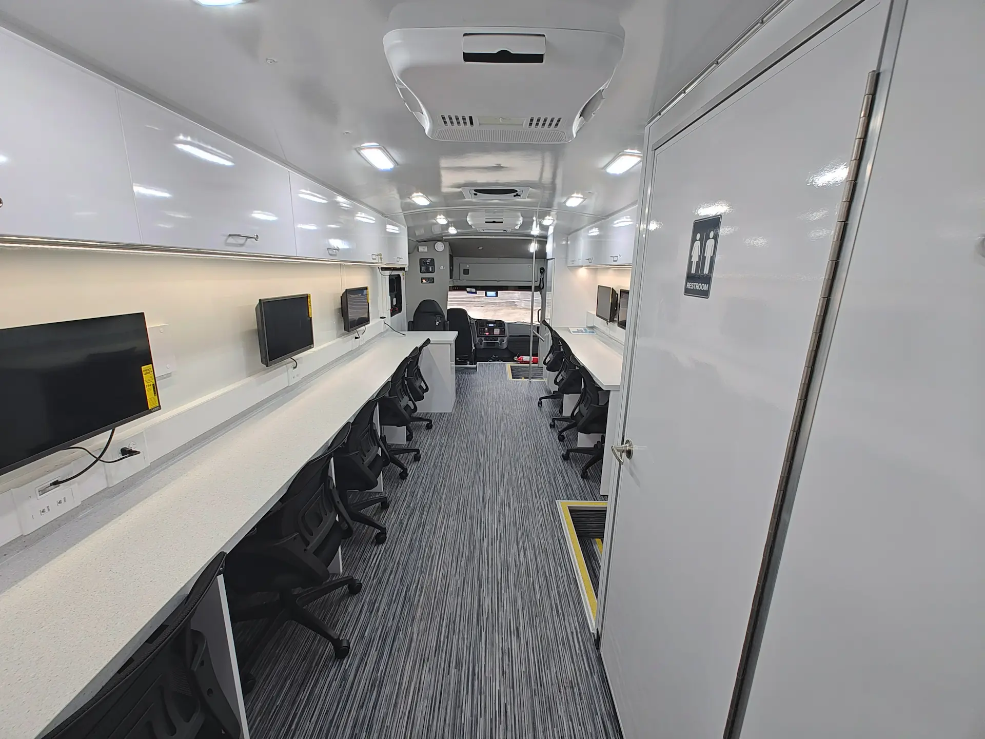 Interior of the City of Norfolk Mobile Workforce Center showing dual workstation desks and overhead cabinets
